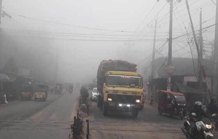 কুয়াশা থাকায় সড়কে হেডলাইট জ্বালিয়ে চলছে যানবাহনগুলো।