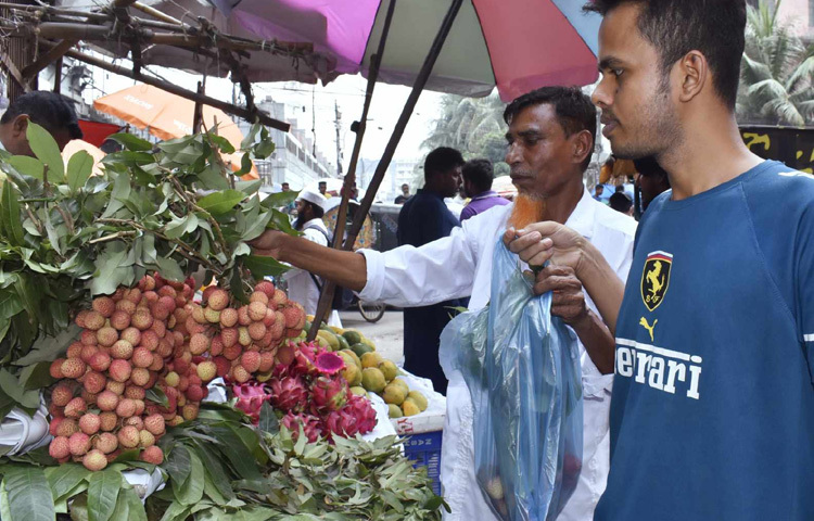 ফলের দোকানে লিচু কিনতে ভিড় করছেন তারা।
