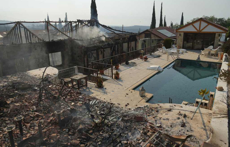 পূর্ব ভূমধ্যসাগরীয় দ্বীপরাষ্ট্র ট্রুডোস পর্বতমালার দক্ষিণ দিকে দাবানলের সময় সাইপ্রাসের সৌনি গ্রামে পুড়ে যাওয়া ঘরবাড়ি দেখা যাচ্ছে।