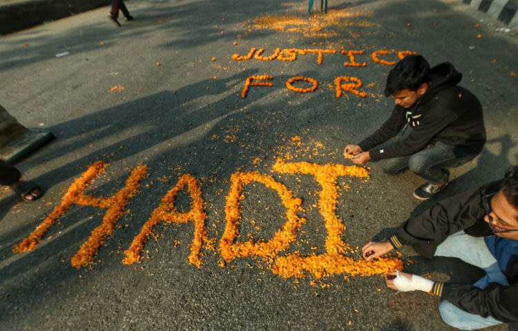 ফুল দিয়ে সড়কে হাদির নাম লিখছেন অবরোধকারীরা।