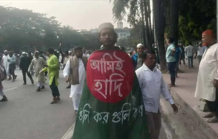 শরীরে লাল পতাকা জড়িয়ে হাদির জানাজায় অংশ নিয়েছেন সাভার কলেজের শিক্ষার্থী আরিফিন শাওন। হাদিকে চোখের সামনে কোনদিন দেখেননি। কিন্তু তার চোখ থেকে অঝোরে ঝরছে পানি। শাওনকে দেখে মনে হয় তার কাছের কোনো আপন জনের বিদায়ের দিন। সত্যিই হাদি আজকে পুরো দেশবাসীর আপনজন হয়ে উঠেছেন।