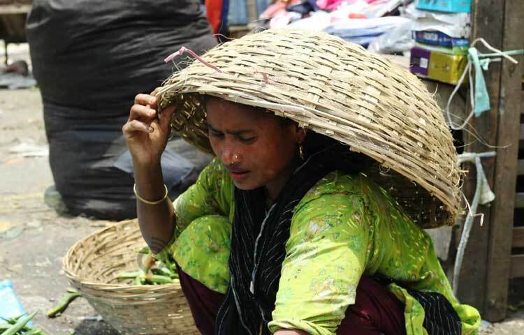 ঝুড়ি মাথায় সবজি বিক্রি করছেন এক নারী। ছবি: মাহবুব আলম