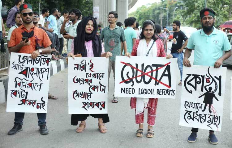 ‘নারীই যেখানে অগ্রসর কোটা সেখানে হাস্যকর’-লেখা প্ল্যাকার্ড নিয়ে দাঁড়িয়ে আছে শিক্ষার্থী। ছবি: মাহবুব আল