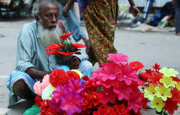 আর্টিফিশিয়াল ফুলগাছ বিক্রি করছেন এক বৃদ্ধ।