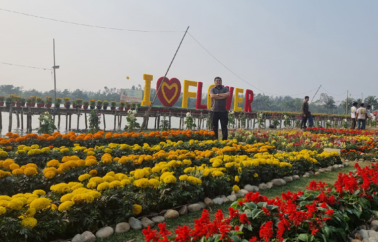 এক পাশে ফুলের বাগান, অন্য পাশে লেক। এখানে দাঁড়িয়ে ছবি তুলছেন দর্শনার্থীরা। ছবি: এম মাঈন উদ্দিন