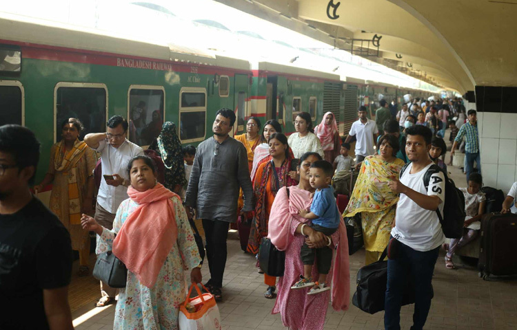 সকাল থেকে স্টেশনের প্ল্যাটফর্মজুড়ে ঘরমুখো মানুষের ভিড়, ক্লান্ত চোখে ভেসে ওঠে প্রিয়জনের মুখ।
