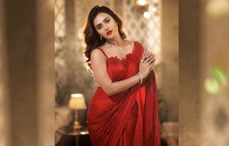 টকটকে লাল শাড়ির সঙ্গে অভিনেত্রী বেছে নিয়েছেন মিনিমালিস্ট ডিজাইনের হীরার গয়না। হীরার ছোট ঝোলানো দুল, পেনড্যান্ট স্টাইল নেকপিস, আংটি আর চুড়িতে বেশ মানিয়েছে তাকে।