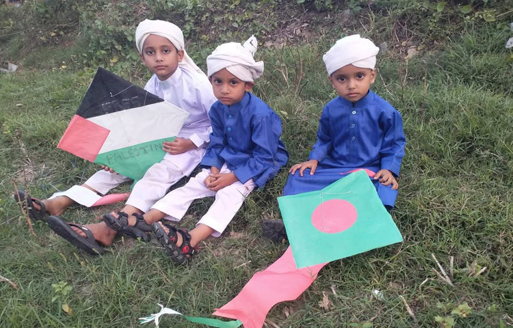 ঘুড়ি হাতে বসে আছে কোমলমতি শিশুরা।