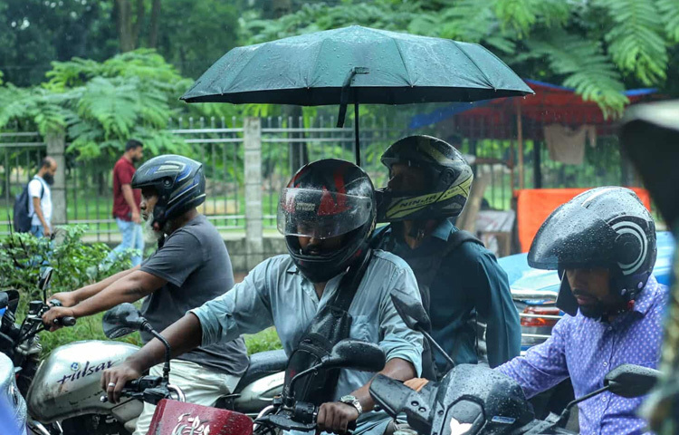 রামপুরা এলাকায় সকাল ৮টা নাগাদ শুরু হয় বৃষ্টির ছোঁয়া। পুকুরপাড়ে দাঁড়িয়ে থাকা গাছগুলো যেন ধুয়ে নিচ্ছিল ক্লান্তি। বাসের অপেক্ষায় থাকা মানুষের কাঁধে ছাতা, কেউবা আবার এক হাত দিয়ে ব্যাগ বাঁচাচ্ছেন, আরেক হাতে ফোনে ব্যস্ত। 
রাস্তায় জমে থাকা হালকা পানির মাঝে ছুটে চলেছে রিকশা, বাইক। পথচারীদের কারও কারও চোখে এই ভেজা সকাল যেন উপভোগ্য এক বিরতি।
