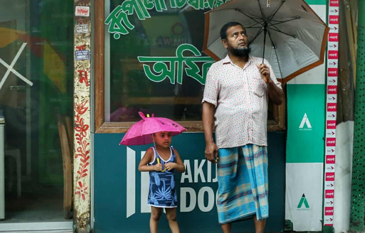 কেউ বসে আছেন ছাতা হাতে, কেউ আবার চায়ের কাপ নিয়ে জানালার পাশে। সব মিলিয়ে শহরের গতি কমে এলেও দৃশ্যপটে যোগ হয়েছে এক ধরনের নান্দনিকতা।