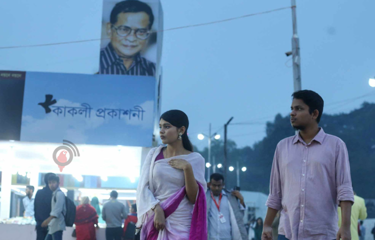 শাড়ি পরে সঙ্গী নিয়ে বইমেলায় ঘুরতে এসেছেন এক তরুণী। ছবি: মাহবুব আলম