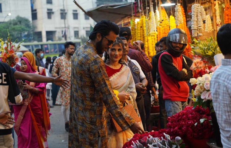 প্রিয় মানুষের জন্য পছন্দের ফুল কিনতে ব্যস্ত যুবক। তার দিকেই অপলক দৃষ্টিতে তাকিয়ে আছে তরুণী। ছবি: মাহবুব আলম