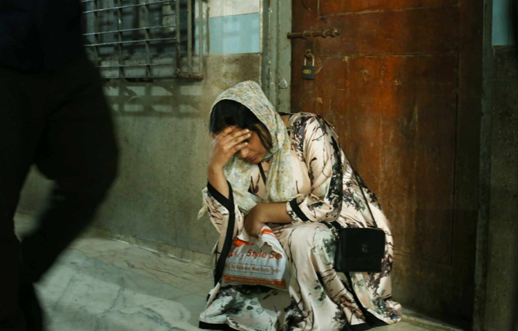 হাসপাতালে করিডোরে মাথা হাত দিয়ে বসে আছেন নিহতের স্বজন। ছবি: মাহবুব আলম