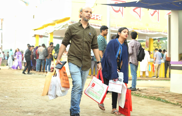 দুই হাত ভরে বই কিনে নিয়ে যাচ্ছেন পাঠকরা। ছবি: মাহবুব আলম