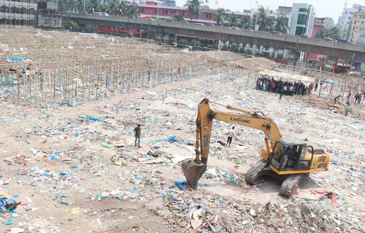 সরেজমিনে দেখা যায়, বঙ্গবাজারের সামনের অংশে একটি ভেকু দিয়ে বাঁশের কাঠামো সরিয়ে ভেঙে গুঁড়িয়ে দেওয়া হচ্ছে। সিটি করপোরেশন সম্পত্তি বিভাগের কর্মকর্তা-কর্মচারী ও বঙ্গবাজার দোকান মালিক সমিতির নেতারা উপস্থিত থেকে বিষয়টি দেখভালের দায়িত্ব পালন করছেন। ছবি: মুসা আহম্মেদ
