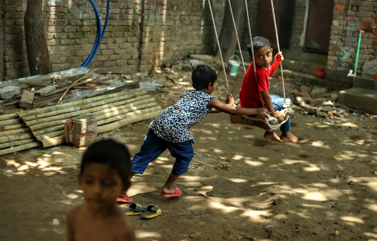 বাড়ির সামনের উঠোনে দোলনা ঝুলিয়ে দোল খেতে ব্যস্ত শিশুরা। ছবি: মাহবুব আলম