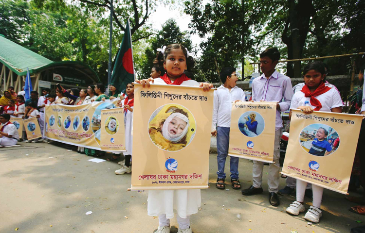 ‘ফিলিস্তিনি শিশুদের বাঁচতে দাও’ ব্যানারে জাতীয় প্রেস ক্লাবের সামনে মানববন্ধন করছে খেলাঘরের সদস্যরা। ছবি: বিপ্লব দীক্ষিত