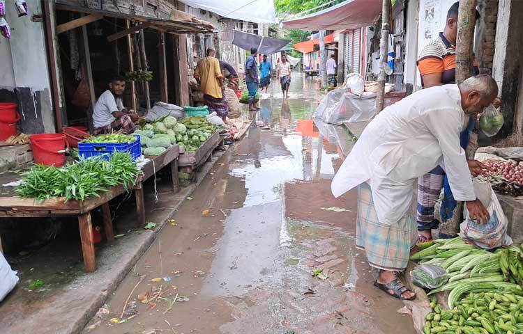 ব্যবসাপ্রতিষ্ঠানসহ সড়কে পানি ওঠায় অনেকেই দোকান বন্ধ করে মালামাল নিরাপদে সরিয়ে নিচ্ছেন। ছবি: জাগো নিউজ
