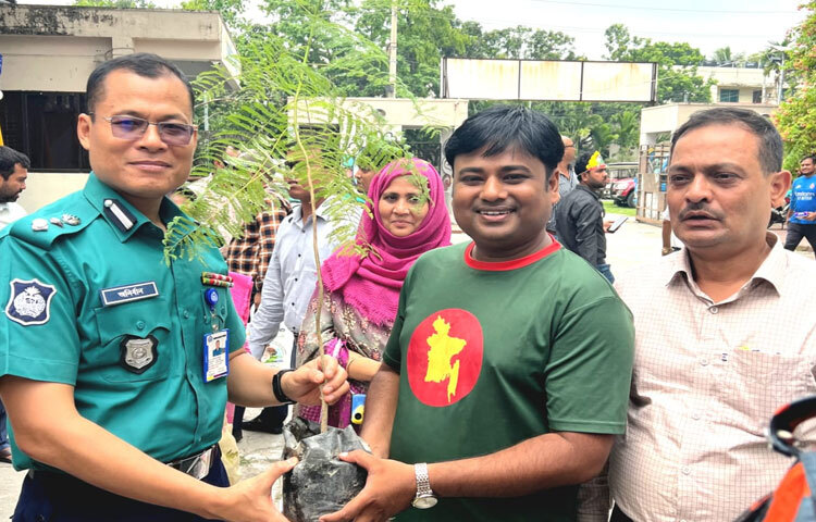 রাজশাহী রেঞ্জের ডিআইজি অনির্বাণ চাকমার হাতে গাছ তুলে দিচ্ছেন বিরল বৃক্ষ ও নবান্ন কৃষি খামারের স্বত্বাধিকারী মাহবুবুল ইসলাম পলাশ। ছবি: জাগো নিউজ