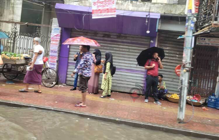 বৃষ্টির তীব্রতায় ছাতা থাকা স্বত্বেও ভিজতে হয়েছে অনেক পথচারীকে। ছবি: রায়হান আহমেদ