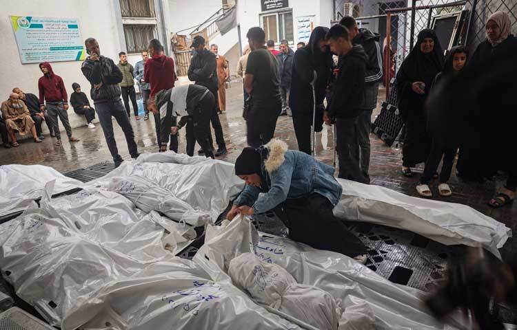 স্বজনের মরদেহ খোঁজে বেড়াচ্ছেন এক অসহায় নারী। ছবি: এএফপি