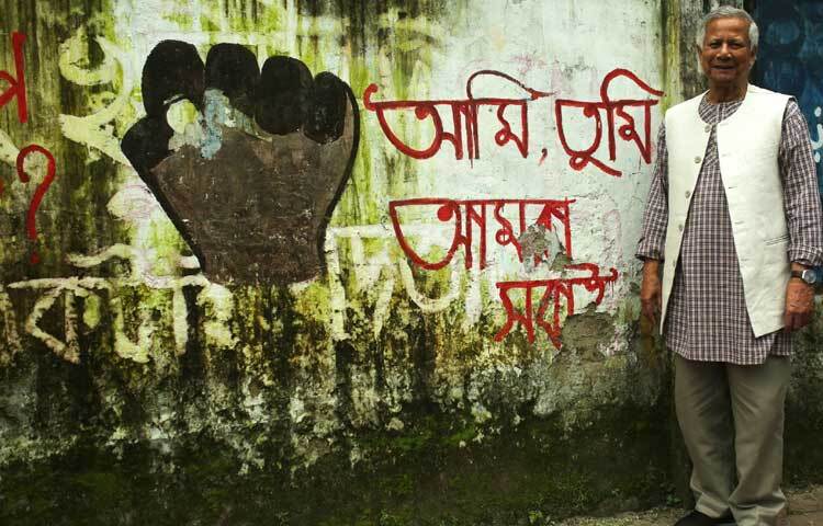 দেয়ালে লেখা, ‘আমি, ‍তুমি, আমরা সবাই’ সামনে দাঁড়িয়ে ক্যামেরাবন্দি হয়েছেন অধ্যাপক ড. মুহাম্মদ ইউনূস।