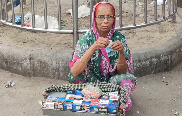 কমলাপুর রেলওয়ে স্টেশনের সামনে পান-বিড়ি-সিগারেট ফেরি করে বিক্রি করছেন ৭০ বছর বয়সী আছিয়া বেগম।