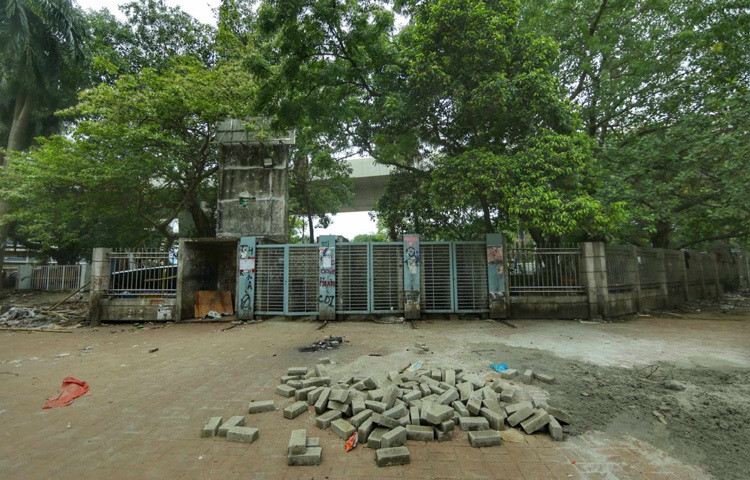 দেয়াল তুলে বন্ধ করে দেওয়া হয়েছে টিএসসি সংলগ্ন প্রধান ফটক। চারপাশে শুধু নির্মাণকাজের ধুলো, প্রশাসনিক সিলমোহরের গন্ধ আর একরাশ শূন্যতা।