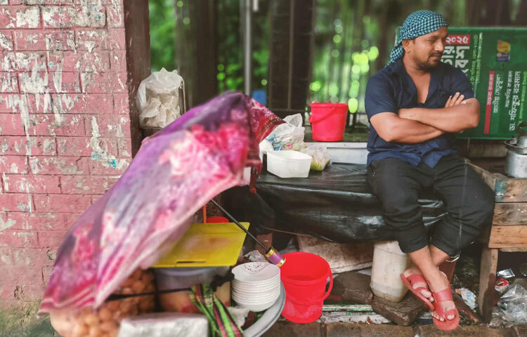 তবুও তারা লড়াই করেন। কাল সূর্য উঠলে হয়তো আবার শুকিয়ে নেবেন ভেজা জামা-কাপড়, আবার সাজাবেন দোকান, আবার ডাক দেবেন ক্রেতাকে। এই ছোট ছোট টিকে থাকার সংগ্রামের ভেতরেই লুকিয়ে আছে তাদের জীবনবোধ, বেঁচে থাকার এক অদম্য গল্প।