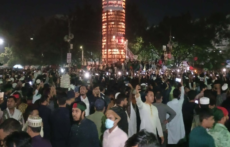 স্লোগানের ফাঁকে ফাঁকে বিক্ষোভকারীরা বলছেন, হাদির মরদেহ ঢাকায় আসা মানেই নতুন অধ্যায়। বিচার না হওয়া পর্যন্ত ঘরে ফিরবেন না তারা।