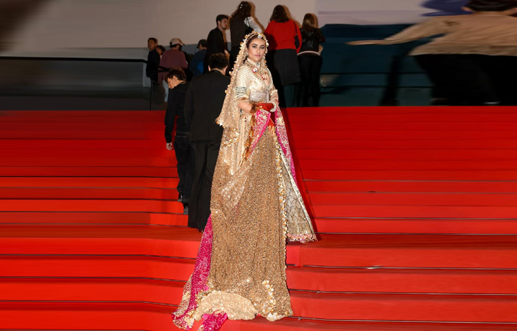 ঝলমলে ব্রাইডাল সোনালি লেহেঙ্গা, ম্যাজেন্টা বর্ডার দেওয়া জমকালো ওড়নায় দারুণ মানিয়েছে তাকে।