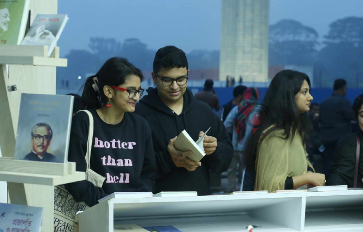 বইমেলার স্টলে বই দেখছেন এক যুগল। ছবি: মাহবুব আলম