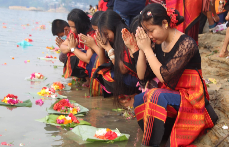 এদিন ফুল ভাসানোর মধ্যে দিয়ে গঙ্গা মায়ের কাছে প্রার্থনা করছেন পাহাড়ি তরুণ-তরুণী। ছবি: সাইফুল উদ্দীন