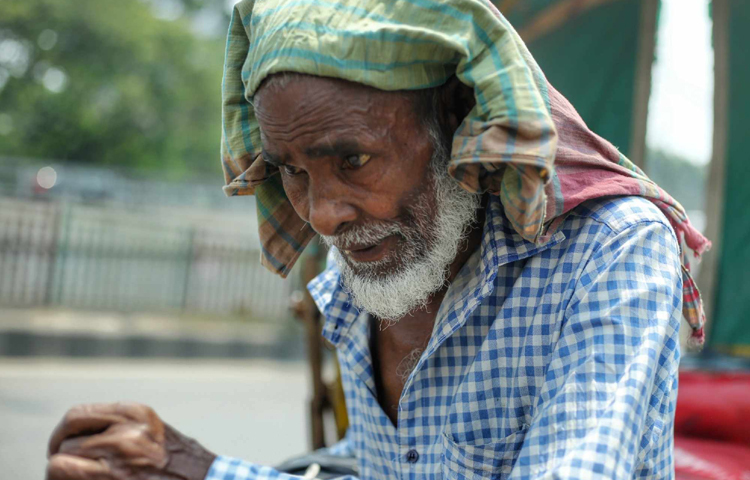 ভ্যান বা রিকশাচালকরা ট্রাফিক সিগন্যাল বা জ্যামে আটকা পড়লেই মাথায় গামছা দিয়ে রোদ থেকে বাঁচার চেষ্টা করছেন। ছবি: মাহবুব আলম