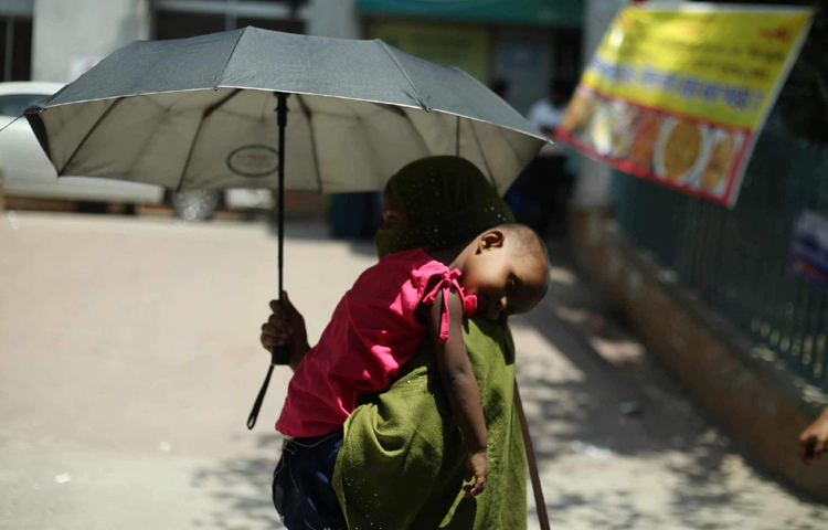 ছাতাতেও যেন মানছে না প্রখর রোদের তাপ। ছবি: মাহবুব আলম
