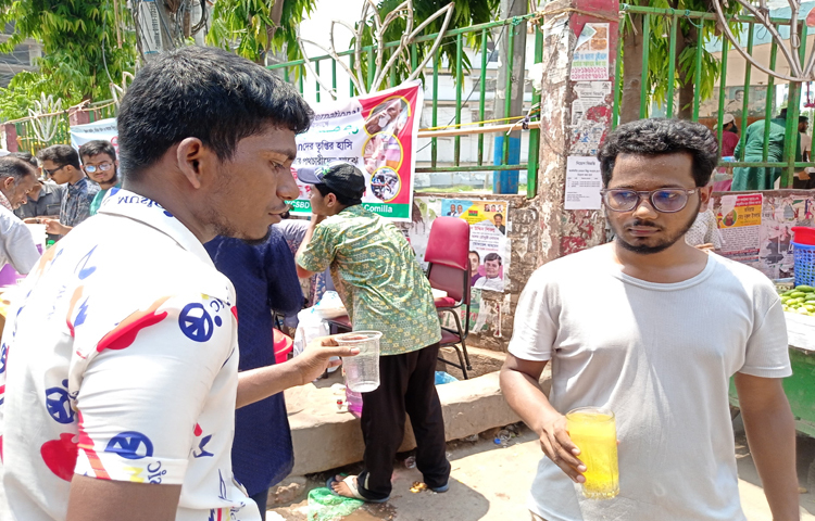 কুমিল্লা নগরীর কান্দিরপাড় এলাকায় পথচারীদের ফ্রিতে শরবত পান করাচ্ছেন স্বেচ্ছাসেবীরা। ছবি: জাহিদ পাটোয়ারী