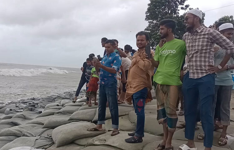 পর্যটকদের কেউ কেউ বড় বড় ঢেউয়ের ছবি তুলতে কিংবা ভিডিও করতে ব্যস্ত। ছবি: আসাদুজ্জামান মিরাজ
