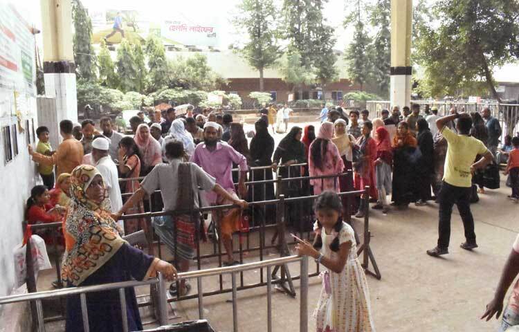 টিকিটের জন্য লাইনে দাঁড়িয়ে অপেক্ষা করছেন যাত্রীরা। ছবি: বিপ্লব দীক্ষিত