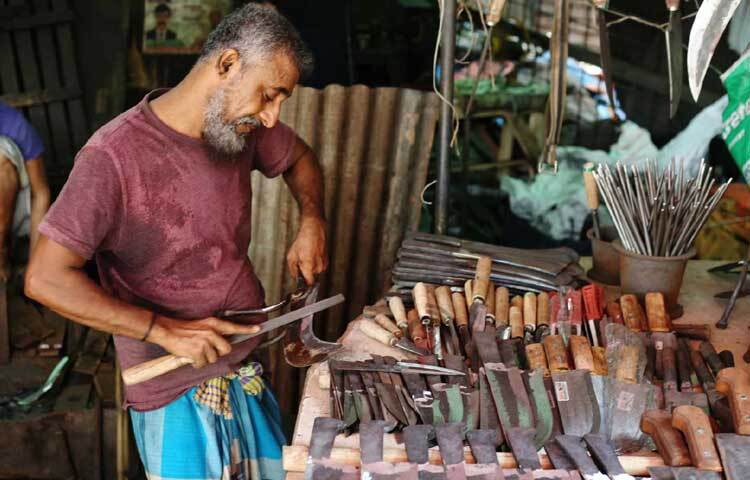 বটিতে শান দিচ্ছেন কামার। ছবি: মাহবুব আলম