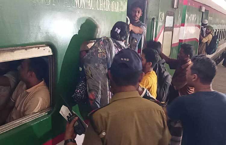 দরজার সামনে অতিরিক্ত ভিড় হওয়ায় জানালা দিয়ে ভেতরে যাওয়ার চেষ্টা করছেন এক নারী। ছবি: নাহিদ সাব্বির