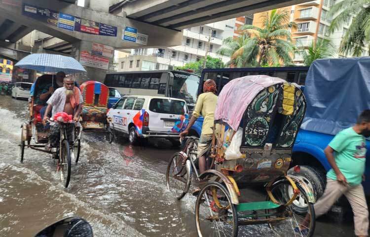 পানি মাড়িয়েই চলাচল করছে যানবাহন। ছবি: রায়হান আহমেদ