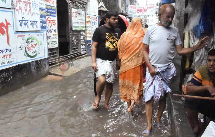 পানি মাড়িয়েই চলাচল করতে হচ্ছে পথচারীদের। ছবি: বিপ্লব দীক্ষিত