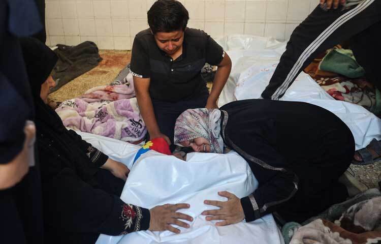 মধ্য গাজার দেইর এল-বালাহ শহরের আল-আকসা হাসপাতালে স্বজনের মরদেহ ধরে নারীর আহাজারি। ছবি: এএফপি