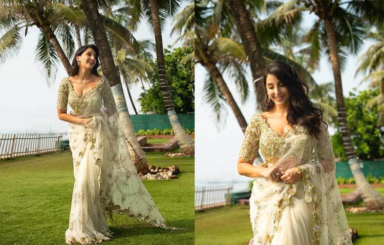 সাদা শিয়ার ফেব্রিকের শাড়ি আর ডিপ নেক ব্লাউজে আবেদনময়ী নোরা।