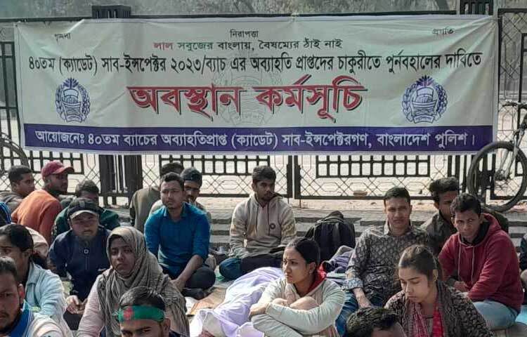 কেউ কেউ প্ল্যাকার্ড বিছিয়ে বসে আছেন। নারীরাও রয়েছেন।