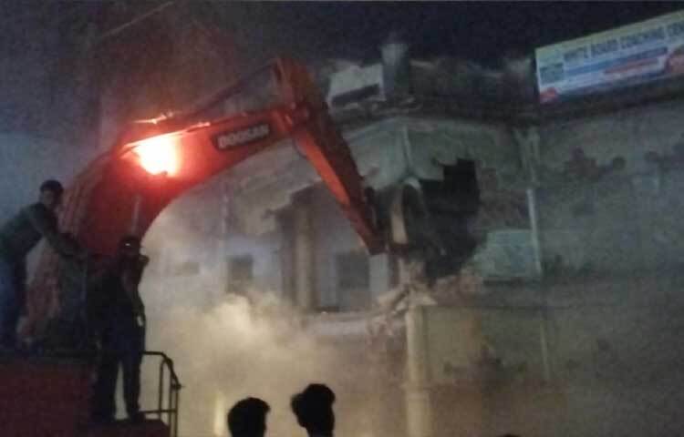 ৬ ফেব্রুয়ারি রাতে শহরের প্রাণকেন্দ্র চাষাড়া এলাকায় অবস্থিত বাসভবনটি ভেকু দিয়ে গুঁড়িয়ে দেওয়া হচ্ছে।