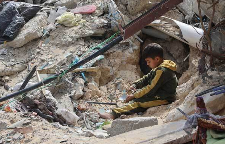 ইসরায়েলের হামলায় গাজা সিটিতে ধ্বংস হয়ে যাওয়া একটি ভবনের মাঝে বসে আছে এক অবুঝ শিশু।