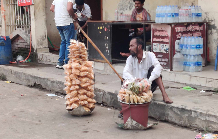 মিরপুর বেড়িবাঁধ এলাকায় রাস্তার দুপাশে ঘুরতে বের হওয়া মানুষের ভিড়। তার মধ্যে ফেরি করে পাঁপড় বিক্রি করছেন মধ্যবয়সী আজিবর আলী।