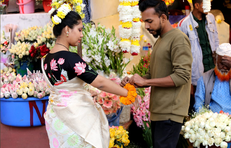 প্রিয় মানুষটির হাতে ফুল বেঁধে দিচ্ছে এক যুবক। ছবি: বিপ্লব দীক্ষিত