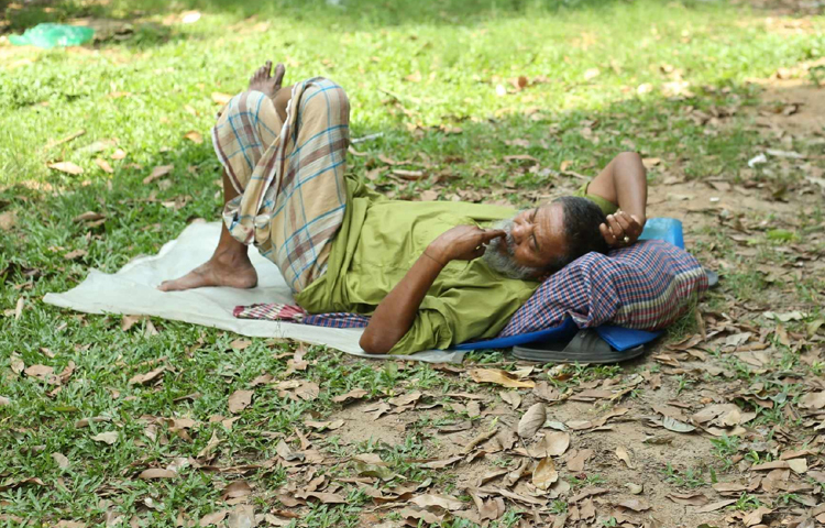 কোলাহল মুক্ত পার্কে শুয়ে আছেন বৃদ্ধ। ছবি: মাহবুব আলম